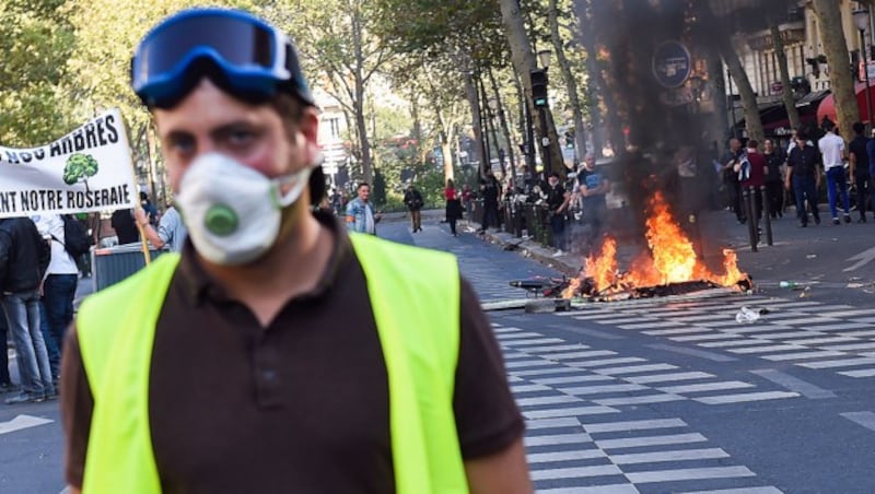 Die „Gelbwesten“ gehen auch mit der Zeit. Rechts hinter dem Demonstranten brennt ein E-Scooter. (Bild: APA/AFP/Lucas BARIOULET)