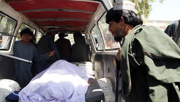 Eine bei der Attacke in der Provinz Helmand getötete Frau wird abtransportiert. (Bild: AP)