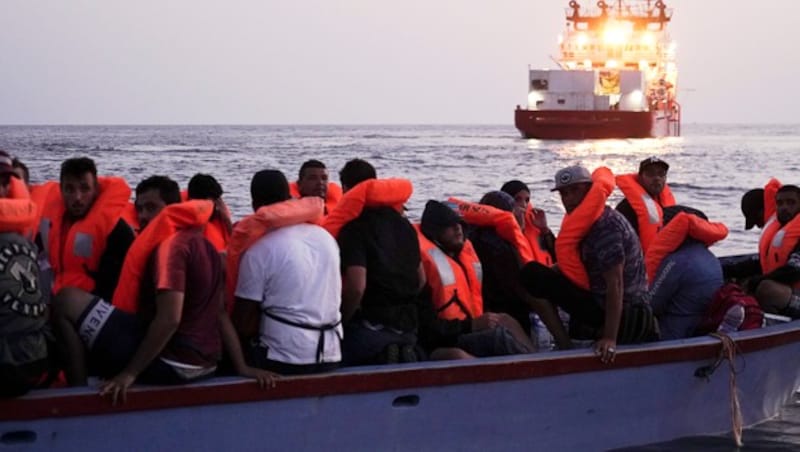 Eine alltägliche Szene im Mittelmeer: Migranten warten in einem völlig überfüllten Boot auf ihre Rettung. (Bild: AP)