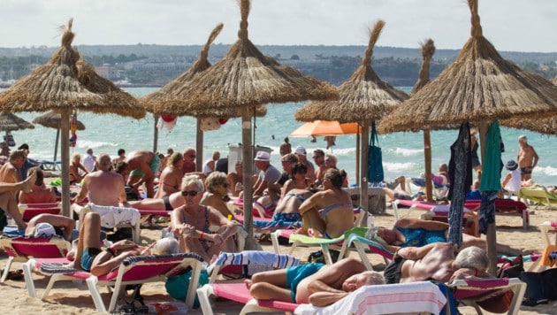 Touristen am Strand von Palma de Mallorca (Bild: AFP)