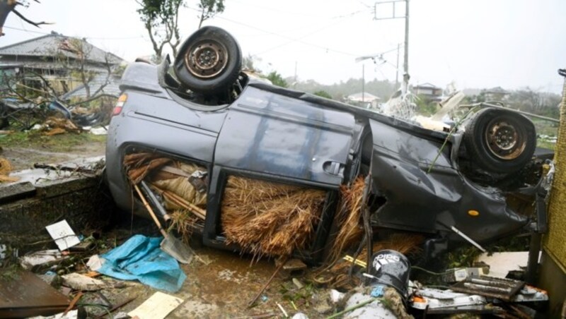 An overturned car lies on the ground following a strong wind in Ichihara, Chiba, near Tokyo Saturday, Oct. 12, 2019. Under gloomy skies, a tornado ripped through Chiba on Saturday.(Kyodo News via AP) (Bild: AP)