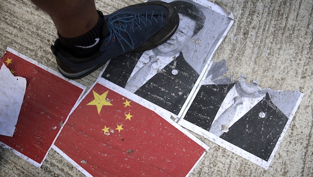 Demonstranten in Hongkong zertrampeln ein Bild des chinesischen Staatschefs Xi Jinping. (Bild: AFP)