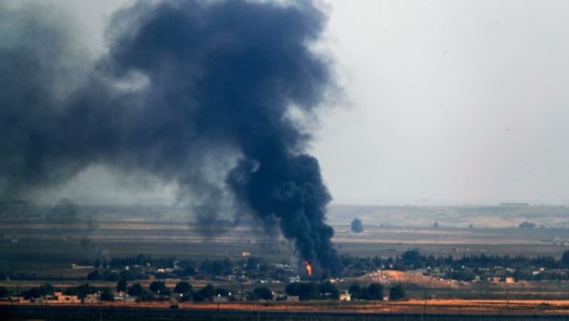 Flammen und Rauch in der türkisch-syrischen Grenzregion (Bild: AP)