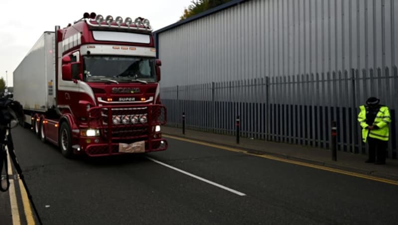 Polizisten neigen ihren Kopf als Zeichen des Respekts, als der Lkw mit den toten Migranten an ihnen vorbeifährt. (Bild: AFP)