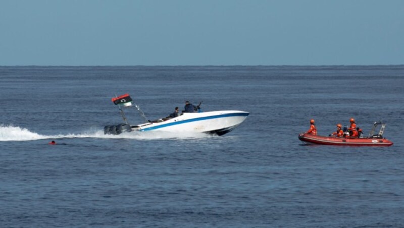 Viele Migranten seien in Panik ins Wasser gesprungen, auch sie seien mit Maschinenpistolen bedroht worden, heißt es von der NGO Sea-Eye. (Bild: AP/Sea-Eye/Lea Ricking)