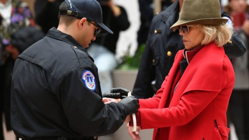 Polizisten legten Jane Fonda Handfesseln an. (Bild: AFP)