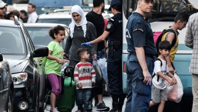 Die griechische Polizei bringt Migranten in einen Bus. (Bild: AFP)