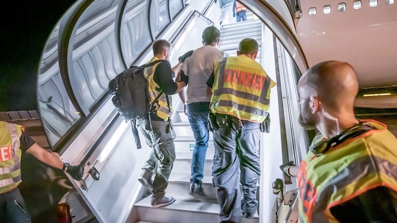 Police officers escort an Afghan onto a charter plane at Leipzig-Halle Airport. (archive picture) (Bild: APA/dpa/Michael Kappeler)