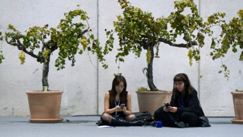 Smartphones checken unter Weinstöcken im Topf (Bild: AFP)