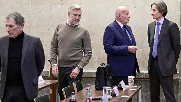 Karl-Heinz Grasser bespricht sich mit seinem Anwalt Manfred Ainedter, während sich Walter Meischberger und Peter Hochegger zu ihren Plätzen auf der Anklagebank begeben. (Bild: APA/HANS PUNZ / APA-POOL)
