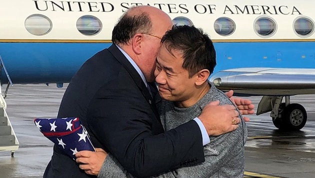Umarmung zwischen US-Botschafter Edward T. McMullen und dem freigelassenen US-Bürger Xiyue Wang auf dem Flughafen von Bern (Bild: APA/AFP/US State Department/HO)