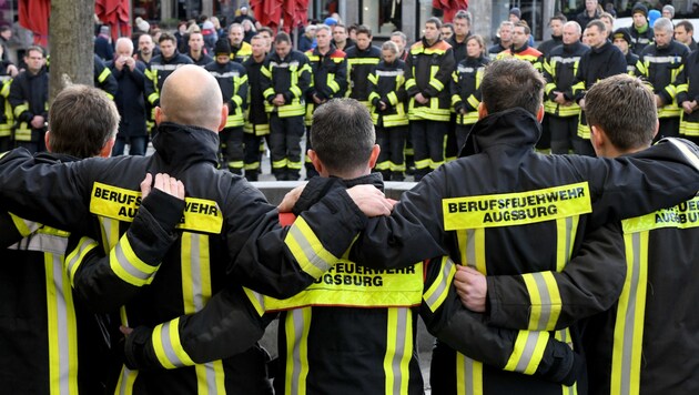 Kameraden des totgeschlagenen Feuerwehrmanns trafen sich, um am Tatort öffentlich zu trauern. (Bild: APA/dpa/Stefan Puchner)