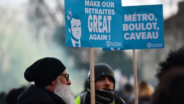 Ein nicht ganz ernst gemeinter Slogan, der Präsident Macron auffordert, die Pensionen der Franzosen in Anlehnung an den Wahlkampfspruch von US-Präsident Donald Trump „wieder großartig zu machen“. (Bild: APA/AFP/Christophe ARCHAMBAULT)