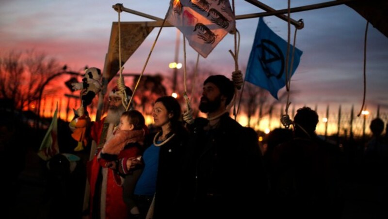 Klimaschützer protestieren vor dem Kongresszentrum in Madrid (Bild: AP)
