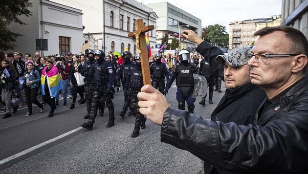Mit Kreuz und Rosenkranz wappnen sich zwei Polen gegen eine Schwulenparade in der Stadt Lublin im Osten des Landes. (Bild: AFP)