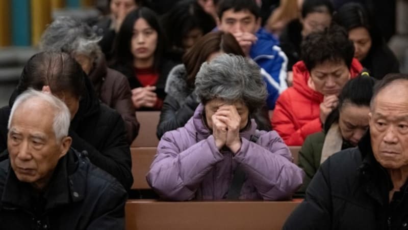 Chinesische Christen beim Beten während einer Weihnachtsmesse in Peking (Bild: AFP )