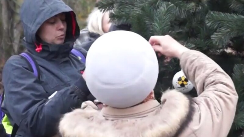 Die Menschen schmückten einen Weihnachtsbaum mit alten Fotos oder anderen Gegenständen, die sie mit dem verhängnisvollen Tag in Verbindung bringen. (Bild: ruptly.tv)