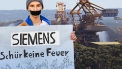 Ein Klimaschutzaktivist demonstriert vor der Siemens-Zentrale in München gegen den Kohlebergwerk-Auftrag in Australien. (Bild: APA/AFP/DPA/Tobias Hase, AFP, krone.at-Grafik)