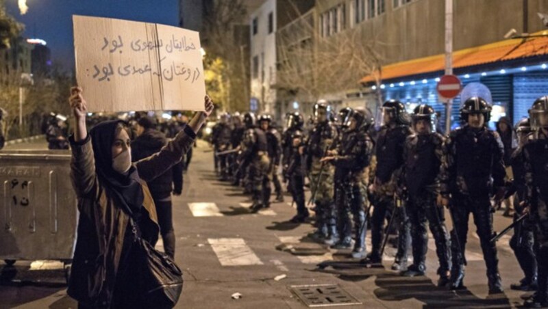 Eine Iranerin protestiert mit einem Schild: „Euer Fehler war unabsichtlich, die Lüge war absichtlich.“ (Bild: AFP)