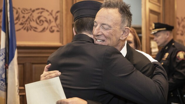 Der „Boss“ Bruce Springsteen ist stolz auf seinen Sohn Sam und umarmt ihn nach der Vereidigung zum Feuerwehrmann. (Bild: AP)