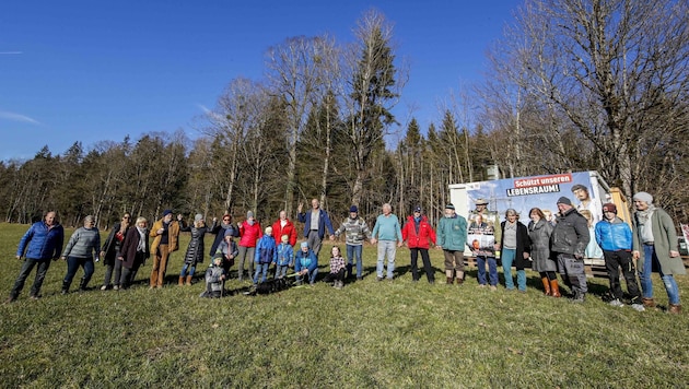 Sie stehen dem Großkonzern mutig entgegen: Die 380-kV-Freileitungsgegner formieren eine Menschenkette als Symbol des Widerstands. Ihren Wachposten in einem Waldstück in Bad Vigaun haben sie in einen Container verlagert. (Bild: Tschepp Markus)