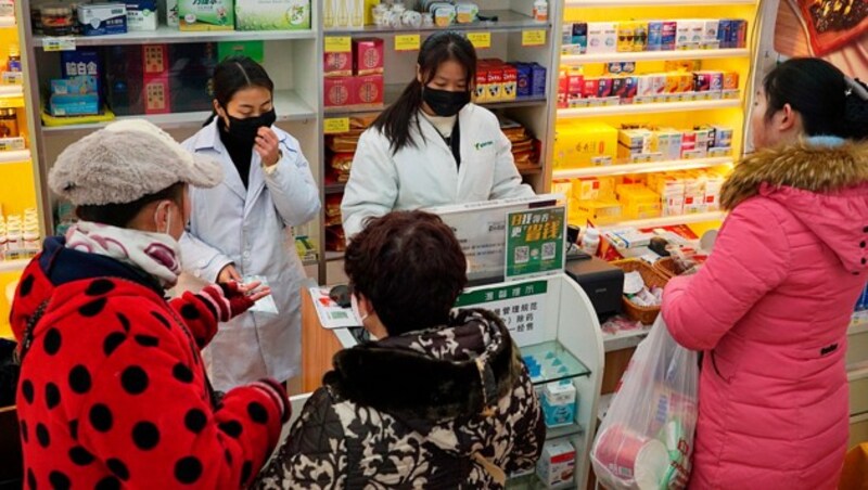 Menschen in der chinesischen Metropole Wuhan decken sich mit Schutzmasken ein. (Bild: AP)