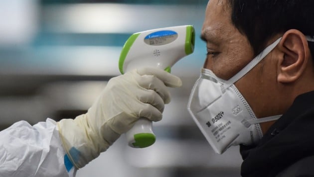 Temperaturmessung bei einem Patienten in der chinesischen Stadt Wuhan (Bild: APA/AFP/Hector RETAMAL)