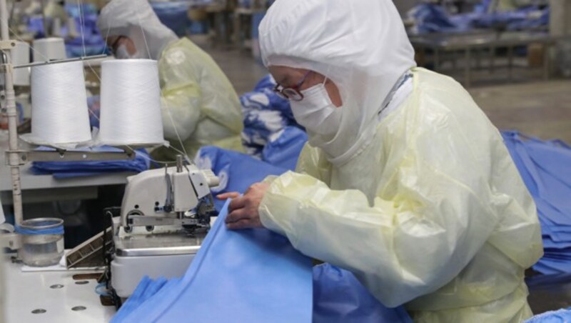 Arbeiter produzieren in China im Akkord Schutzanzüge und Masken. (Bild: AFP or licensors)