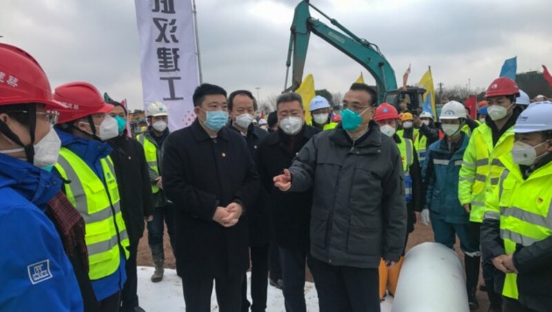 Chinas Premier Li Keqiang (Mitte, re.) hält auf einer der Baustellen eine Rede - ohne seine Atemmaske abzunehmen. (Bild: AFP)