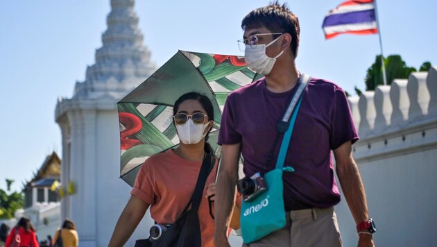 Touristen in Bangkok mit Gesichtsmasken (Bild: AFP)