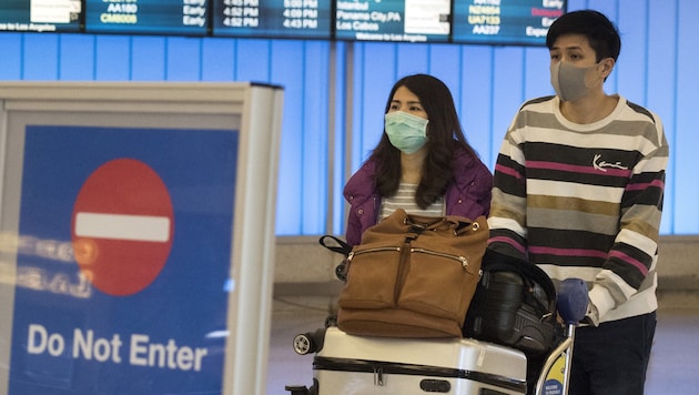 Chinesische Passagiere nach ihrer Landung in Los Angeles (Bild: APA/AFP/Mark RALSTON)