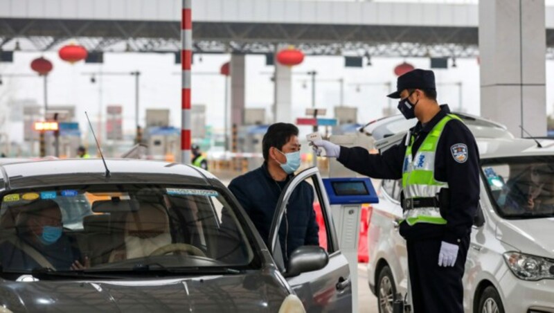 Temperaturkontrolle an einem Checkpoint in Wuhan (Bild: AP)