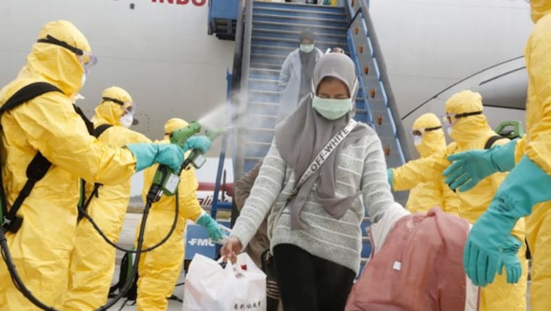 Reisende aus Wuhan werden in Indonesien nach der Ankunft desinfiziert. (Bild: APA/AFP/Indonesian Embassy/HANDOUT)