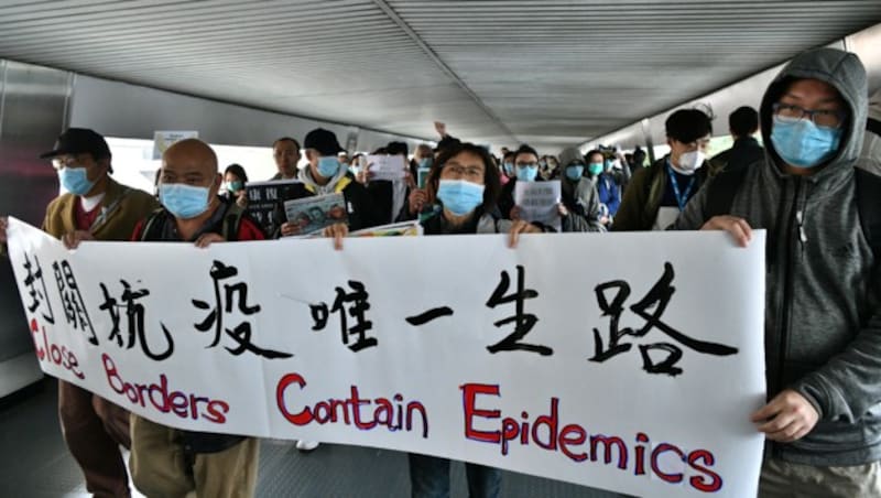 Diese Demonstranten in Hongkong fordern, die Grenzen zu Festland-China zu schließen. (Bild: APA/AFP/ANTHONY WALLACE)