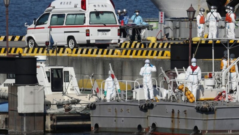 Im Hafen von Yokohama wartet medizinisches Personal auf die nächsten möglichen Patienten. (Bild: APA/AFP/JIJI PRESS/STR)