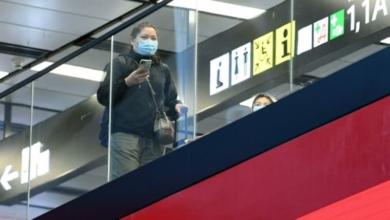 Ein Passagier mit Schutzmaske am Flughafen Wien-Schwechat (Bild: APA/Helmut Fohringer)