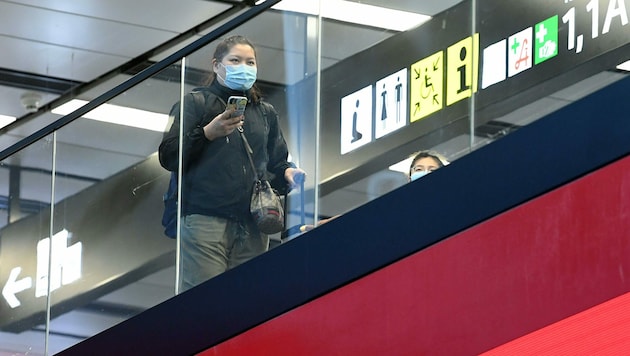 Ein Passagier mit Schutzmaske am Flughafen Wien-Schwechat (Bild: APA/Helmut Fohringer)