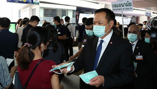 Gesundheitsminister Anutin Charnvirakul beim Verteilen von Schutzmasken (Bild: APA/AFP/Thailand Public Health Ministry/Handout)