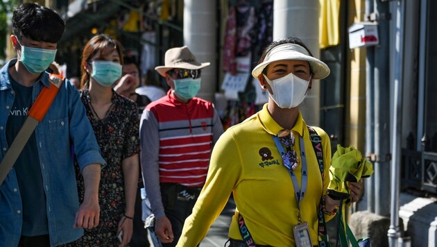 Touristen mit Schutzmasken in Bangkok (Bild: APA/AFP/Lillian SUWANRUMPHA)