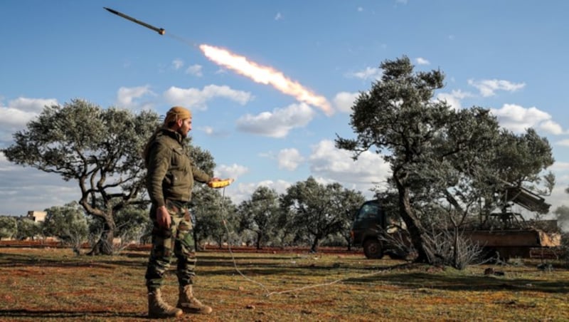 Ein Rebellenkämpfer feuert eine Rakete in Richtung der Stellungen der Assad-Truppen ab. (Bild: APA/AFP/OMAR HAJ KADOUR)