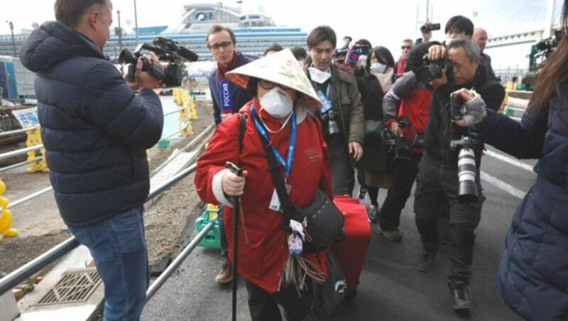 Diese Passagierin wird von Reportern belagert, als sie das Kreuzfahrtschiff verlässt. (Bild: AP)