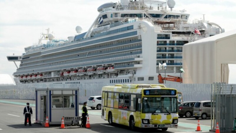 Die meisten Passagiere werden per Bus aus dem Hafen gebracht. (Bild: AP)