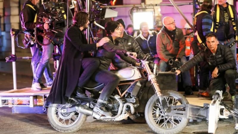 Keanu Reeves und Carrie-Ann Moss drehen eine Szene auf einem Motorrad. (Bild: www.PPS.at)