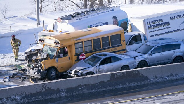 Auch ein Schulbus war betroffen - zum Glück wurde an Bord niemand schwer verletzt. (Bild: AP)