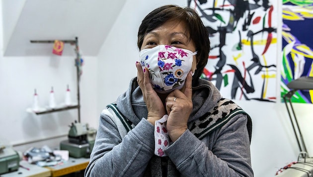 Elase Wong präsentiert eine von ihr geschneidert Atemschutzmaske (Bild: AFP/Isaac Lawrence)