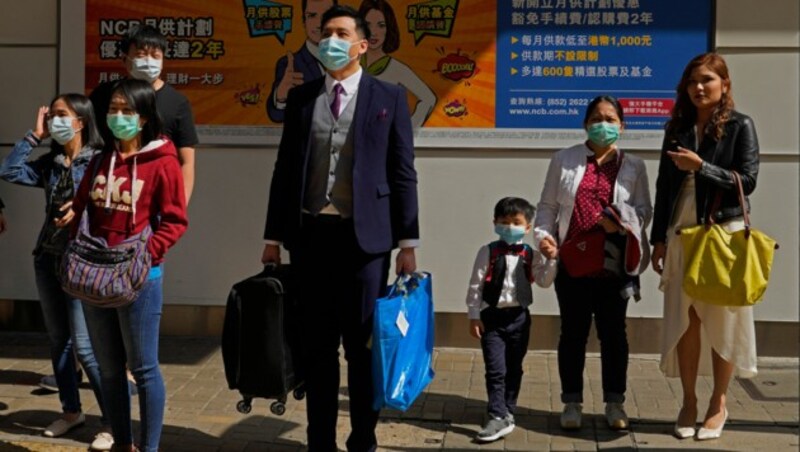 Trotz des Coronavirus versuchen die Menschen in China, wie hier in Hongkong, einem halbwegs geregelten Tagesablauf nachzugehen. (Bild: AP)