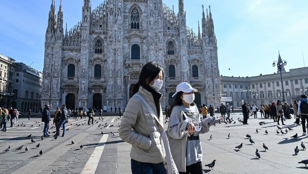 Touristen schützen sich in Mailand mit Gesichtsmasken. (Bild: AFP)