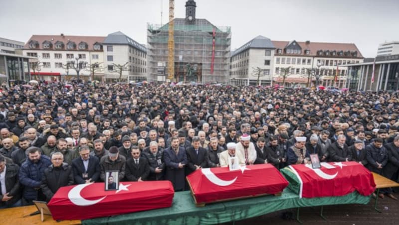 Drei Särge stehen bei einem muslimischen Trauergebet in Hanau auf dem Marktplatz vor vielen hundert Trauernden. (Bild: APA/dpa/Frank Rumpenhorst)