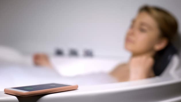 Bei der Smartphone-Nutzung in der Badewanne sollte man das Gerät unter keinen Umständen aufladen. Während vom Handy selbst keine Gefahr droht, können Ladegeräte oder Verteilersteckdosen lebensgefährliche Stromschläge auslösen. (Bild: ©motortion - stock.adobe.com)