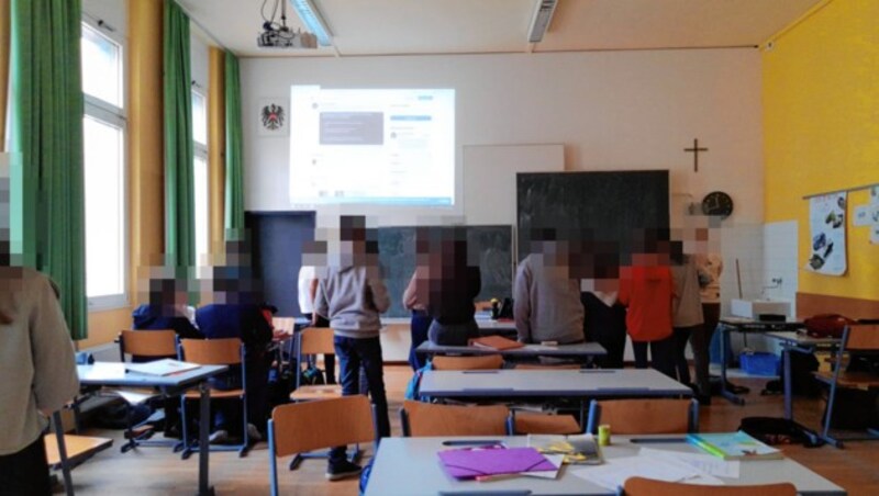 Auch diese 4. Klasse des BGRG 8 wartet gespannt, was passiert. Auf die Wand ist der Twitter-Account der Wiener Polizei projiziert. (Bild: Privat, krone.at-Grafik)